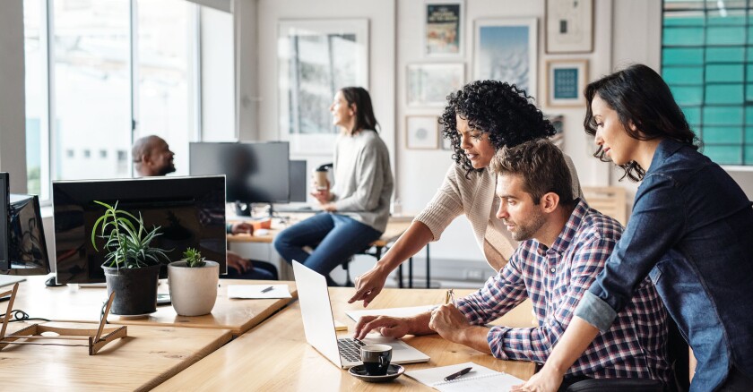 A group of business professionals collaborating ideas around a computer